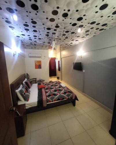 a bedroom with a bed and a ceiling with polka dots at Hotel Rooms DHA in Karachi