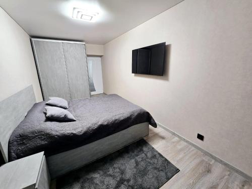 una camera con letto e TV a parete di Apartments a Bălţi