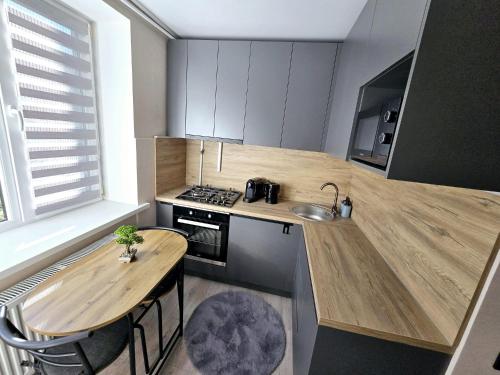 una piccola cucina con tavolo in legno e lavandino di Apartments a Bălţi