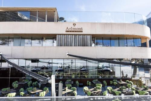 un edificio con mesas y sillas delante de él en Hotel Arlmont 4 Stern Superior, en Sankt Anton am Arlberg