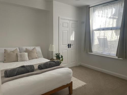 um quarto branco com uma cama e uma janela em New apartment in town centre em Bournemouth