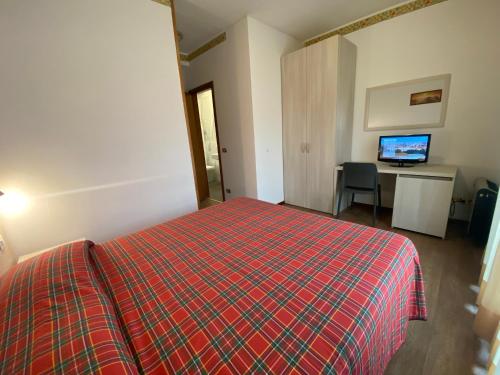 una camera con letto e scrivania con TV di Hotel International a Tarvisio