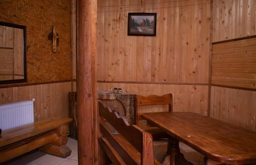 comedor de madera con mesa de madera y bancos en Затишок, en Dragobrat