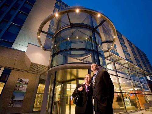 um homem e uma mulher em frente a um edifício em Novotel Zürich Airport Messe em Glattbrugg