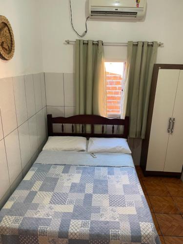 1 dormitorio con 1 cama en una habitación con ventana en Casa Dona Vilma, en Barreirinhas