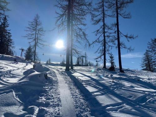 śnieżna droga ze słońcem w tle w obiekcie Freiraum 9 Living Apartment w mieście Sankt Johann im Pongau