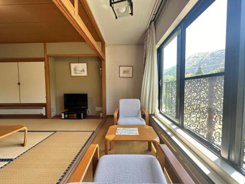 salon z krzesłami i dużym oknem w obiekcie Hakone Fairy Hotel w mieście Hakone