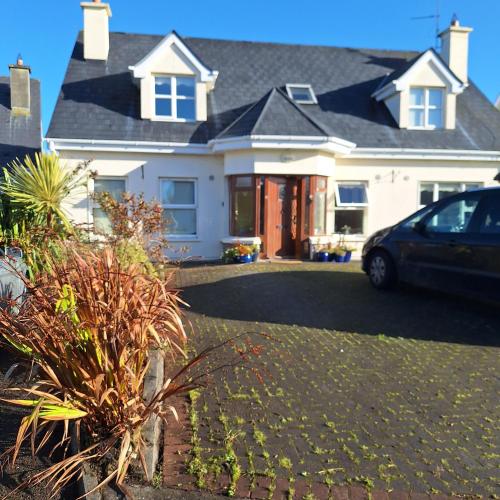 een wit huis met een auto op de oprit bij Lovely Single Room in Listowel Kerry in Listowel