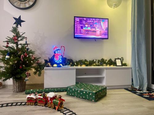 sala de estar con TV y árbol de Navidad en La Brisa Apartments, en Dziwnówek