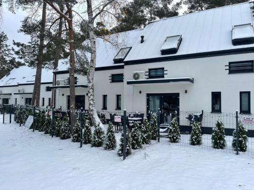 un edificio con un montón de árboles de Navidad en la nieve en La Brisa Apartments, en Dziwnówek