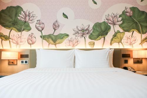 a bedroom with a bed and a wall with flowers at Sivatel Bangkok Hotel in Bangkok