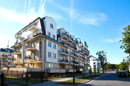 een wit gebouw met balkons in een straat bij Regina Maris by Baltic Home in Świnoujście