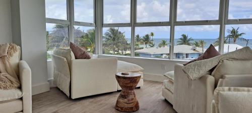 een woonkamer met 2 stoelen en een groot raam bij Newly Remodeled Luxury Beachfront 2-Bedroom Condo in Freeport