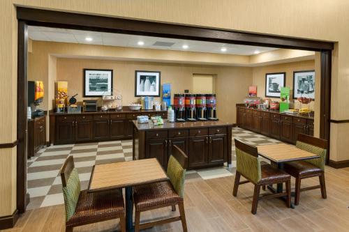 a restaurant with tables and chairs and a counter at Hampton Inn & Suites Williamsport - Faxon Exit in Williamsport