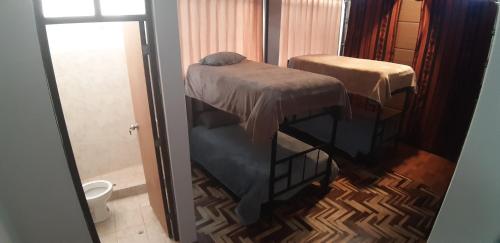 - Baño con 2 camas y aseo en Urpi Wasi Backpackers, en Puno