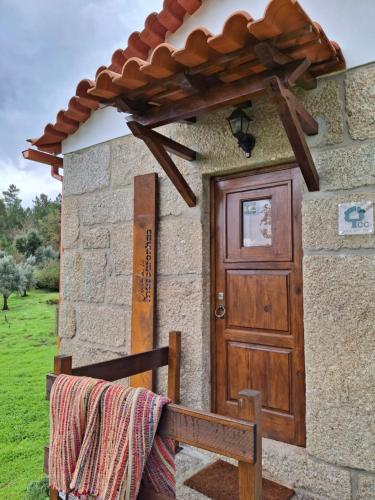 una casa con una porta in legno e una panca di Quinta dos Mascarenhas Nature House a Oliveira do Hospital