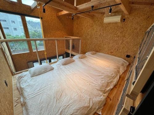 uma cama grande num quarto com uma janela grande em BRB Kamakura Hase em Kamakura