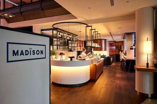 um restaurante com um balcão no meio de uma sala em THE MADISON Hotel Hamburg em Hamburgo