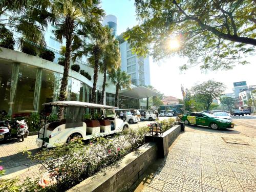 un carro de golf estacionado frente a un edificio en Mondial Hotel Hue, en Hue