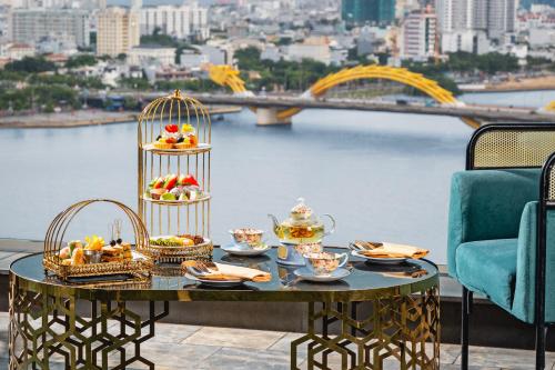 una mesa con comida en ella con vistas a un puente en HAIAN Riverfront Hotel Da Nang, en Da Nang