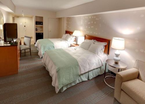 una camera d'albergo con due letti e una televisione di Independent (SPHC) Niagara Fallsview Hotel&Suites a Niagara Falls