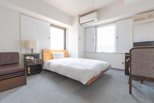 - une chambre avec un lit, une chaise et deux fenêtres dans l'établissement Hotel Alpha Inn Akita - Vacation STAY 67278v, à Akita