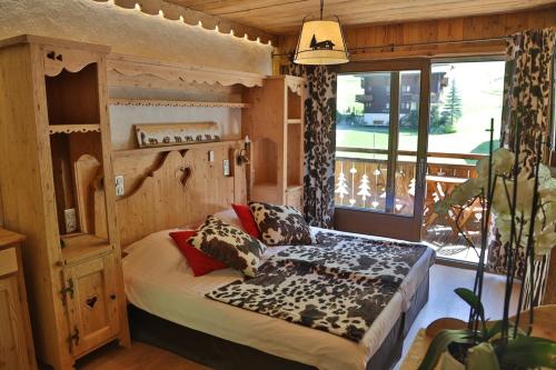 1 dormitorio con 1 cama en una habitación con ventana en Hotel L'Equipe, en Morzine