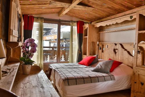 1 dormitorio con 1 cama con almohadas rojas en Hotel L'Equipe, en Morzine