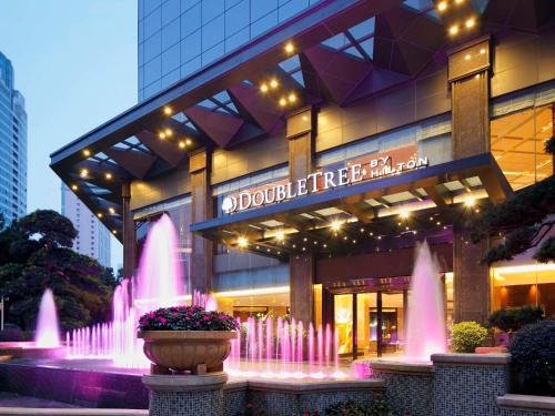 a building with pink fountains in front of it at DoubleTree by Hilton Guangzhou-Free Shuttle Bus to Canton Fair Complex & Overseas Buyer Registration Services during Canton Fair Period in Guangzhou