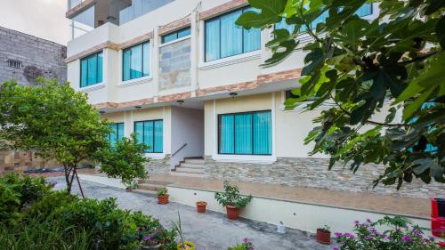 a building with blue windows and plants at Hotel Flamingo in Puerto Ayora