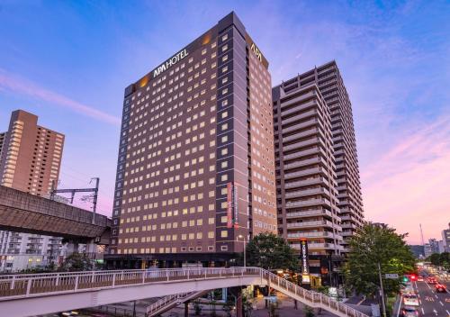 um edifício alto com uma ponte numa cidade em APA Hotel Sendai Eki Itsutsubashi em Sendai