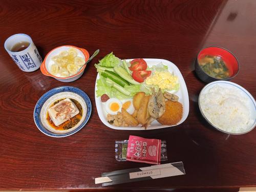 a table with two plates of food and rice at 一日限定一組の宿なんでもん in Naoshima