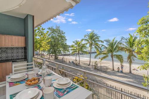 una sala da pranzo con vista sulla spiaggia di Courbaril Hôtel a Les Trois-Îlets