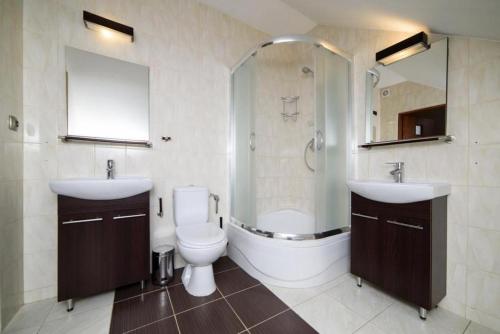 a bathroom with two sinks and a toilet and a shower at Szafir in Rzeszów