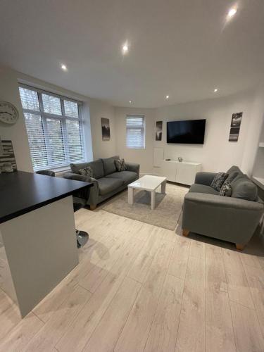 un soggiorno con 2 divani e una TV a schermo piatto di Spacious 2 bedroom apartment a Liverpool