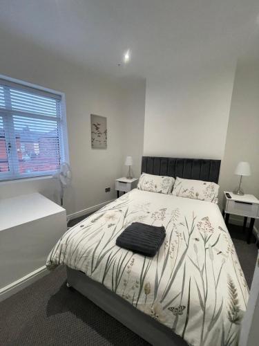 una camera da letto con un letto con un piumone bianco e nero di Spacious 2 bedroom apartment a Liverpool