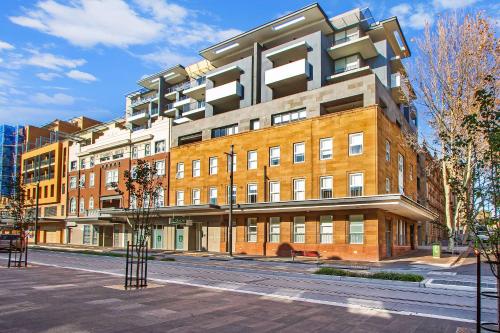 ein großes Backsteingebäude in einer Stadtstraße in der Unterkunft Terminus Apartment Hotel, Ascend Hotel Collection in Newcastle