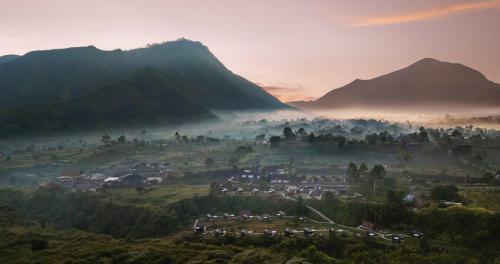 a village in a valley with mountains in the background at Bobocabin Gunung Rinjani, Lombok in Sembalun Lawang