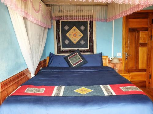 a bedroom with a blue bed with a blue comforter at Peace Home in Sa Pa