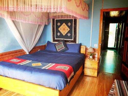 a bedroom with a bed with blue walls at Peace Home in Sa Pa