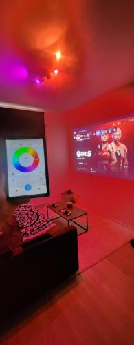 a living room with a large tv and a red wall at My house jacuzzi Billiards in Brussels