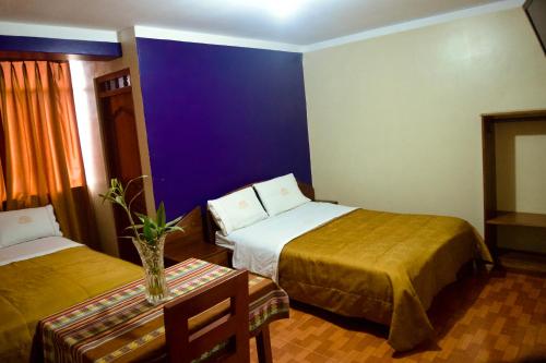 Cette chambre d'hôtel comprend 2 lits et un mur violet. dans l'établissement Hotel California, à Chachapoyas