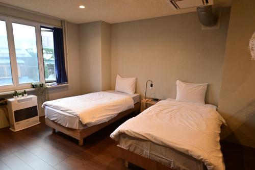 een slaapkamer met 2 bedden en een raam bij otaru - Hotel - Vacation STAY 60536v in Otaru