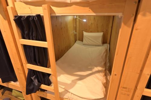 um beliche numa cabina de madeira com uma almofada em Tug-B Women's dormitory - Vacation STAY 60527v em Otaru