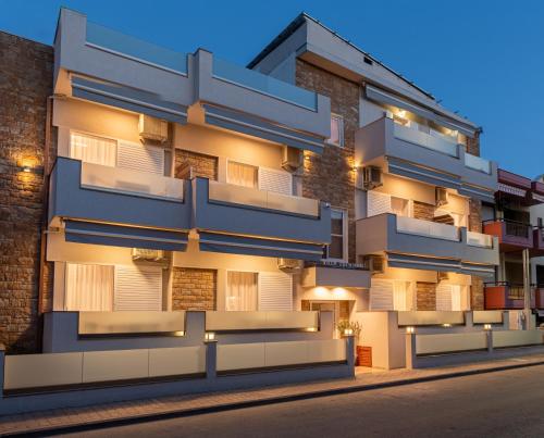 un edificio de apartamentos con balcones azules en una calle en Villa Zoe on the beach, en Sarti