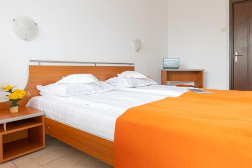 a bedroom with a large bed with an orange and white at HOTEL DUNĂREA in Mamaia