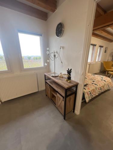 Schlafzimmer mit einem Bett und einem Holztisch in der Unterkunft Appartement au pied des Vignes in Vosne-Romanée