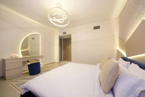 um quarto com uma cama branca e um espelho em Silk Valley - Gorgeous 4b Maid Near Al Hamriyah em Sharjah