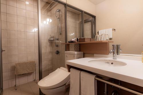 La salle de bains est pourvue de toilettes, d'un lavabo et d'une douche. dans l'établissement Japanese Ryokan Seryo, à Kyoto