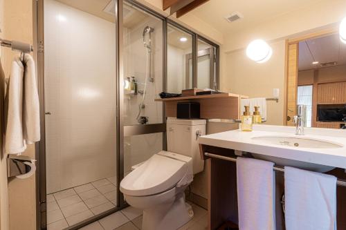 La salle de bains est pourvue de toilettes, d'un lavabo et d'une douche. dans l'établissement Japanese Ryokan Seryo, à Kyoto